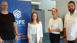 ier Personen stehen vor dem Cope Marketing Banner am Digital Event