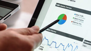 Brand Marketing vs Performance Marketing . Person zeigt mit Stift auf eine Statistik-