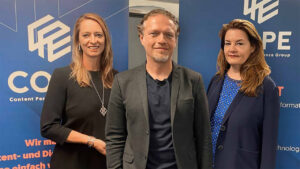 Drei Personen stehen vor der COPE Marketing Banner-Corporate Publishing Event