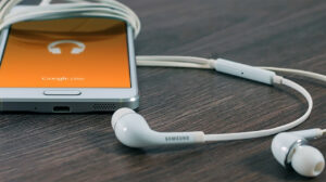 erfolgreicher Podcast-Smartphone liegt am Tisch mit Kopfhörern.