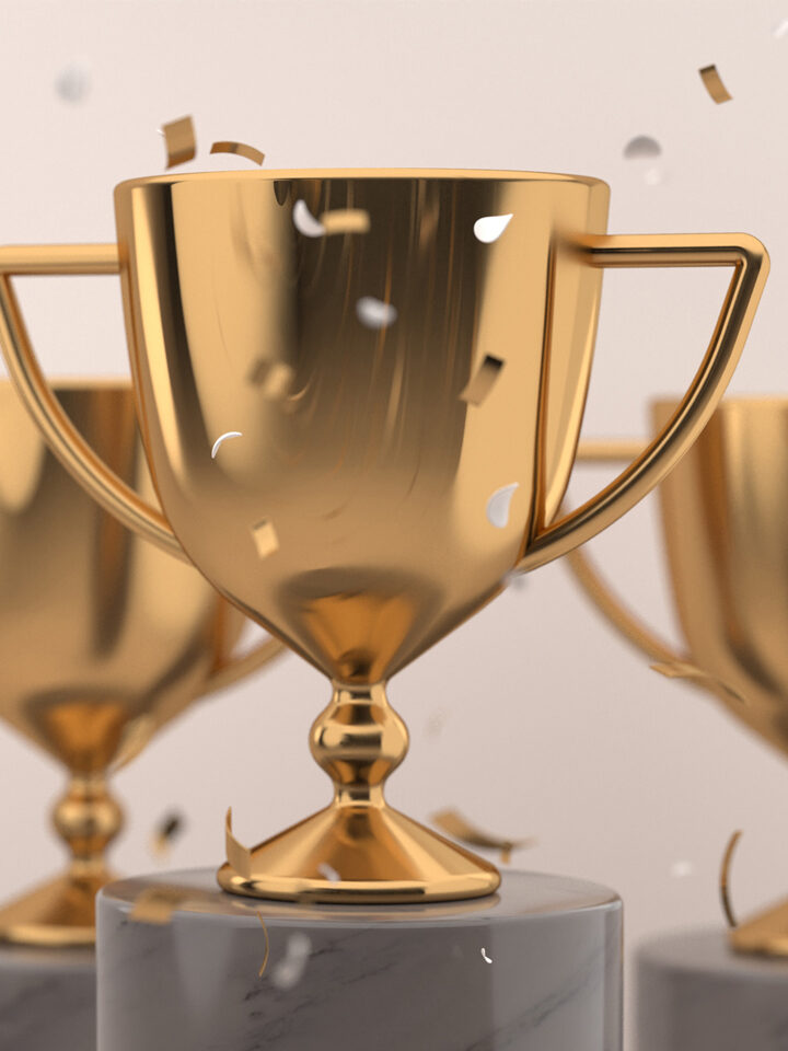 Eine goldene Trophäe auf einem Marmorsockel mit fallendem Konfetti, flankiert von zwei ähnlichen Trophäen im Hintergrund - ein inspirierendes Symbol für hervorragende Leistungen im Content Marketing.